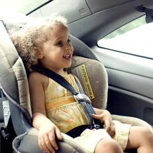 Young cute female child in back seat car set